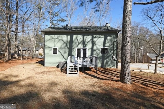 rear view of house featuring a wooden deck