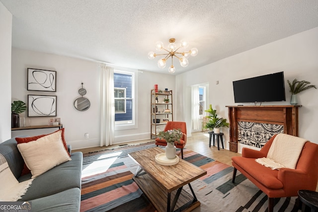 living room with a notable chandelier, a textured ceiling, and light hardwood / wood-style floors