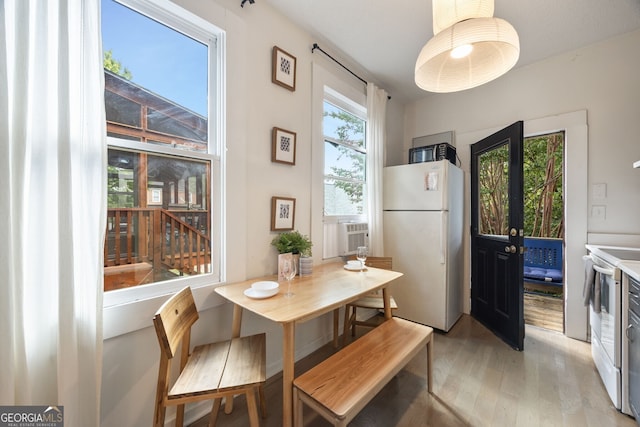 dining space featuring cooling unit and light hardwood / wood-style flooring