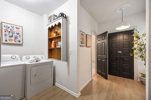 washroom with washing machine and dryer and light hardwood / wood-style floors