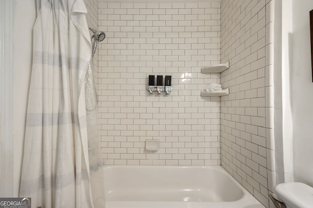 bathroom with shower / tub combo with curtain and toilet