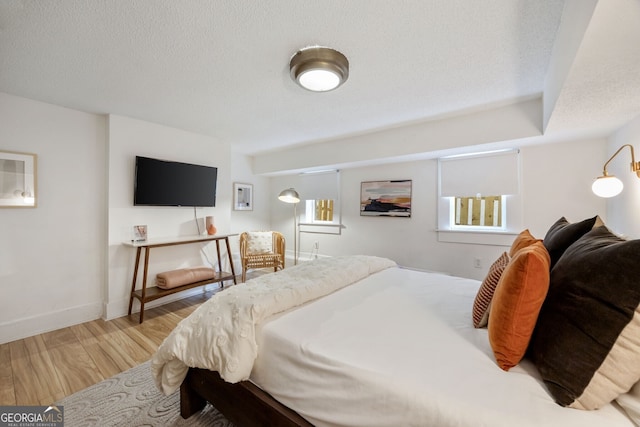 bedroom with light hardwood / wood-style flooring and a textured ceiling