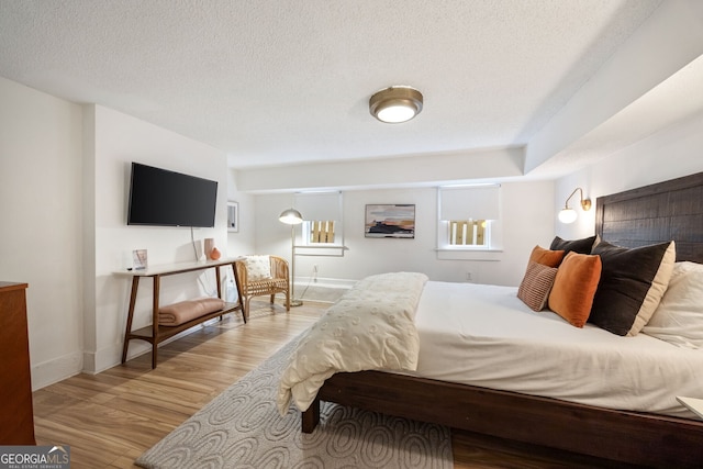 bedroom with a textured ceiling and light wood-type flooring