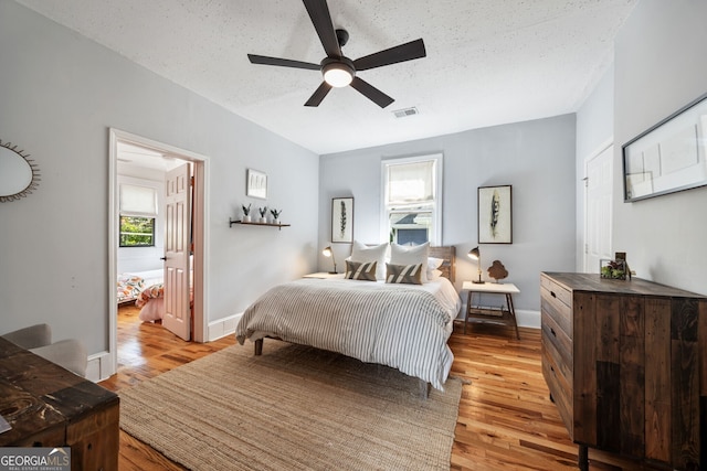 bedroom with a textured ceiling and light wood-type flooring