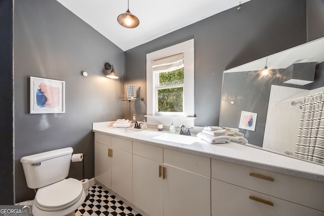 bathroom featuring vanity, toilet, and vaulted ceiling