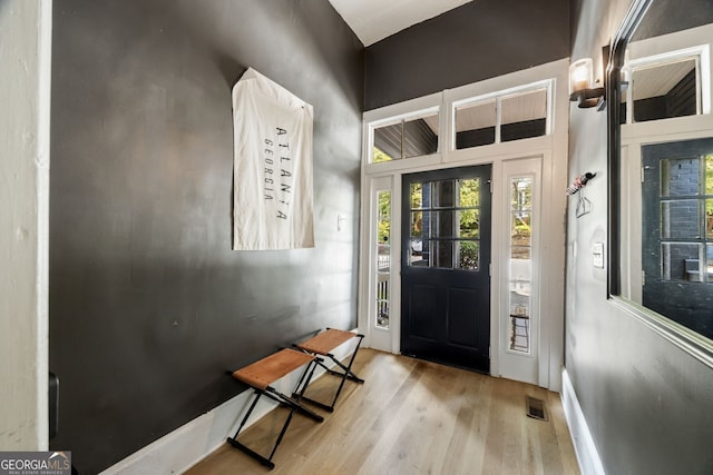 foyer entrance featuring light hardwood / wood-style flooring and a high ceiling