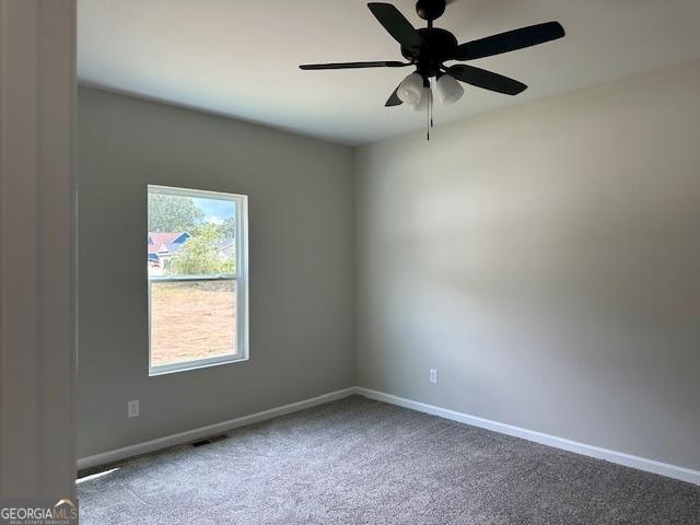 spare room featuring ceiling fan and carpet floors