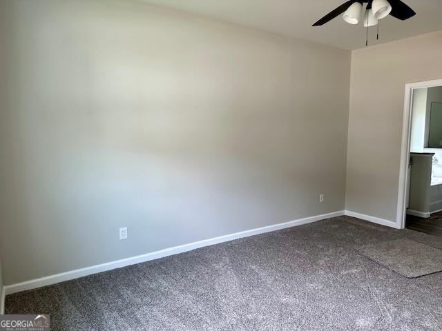 interior space featuring ceiling fan and dark carpet