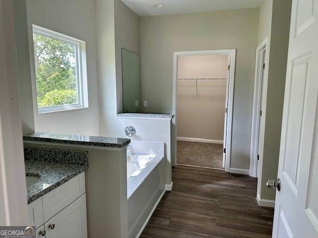 bathroom with hardwood / wood-style floors, vanity, and a bath