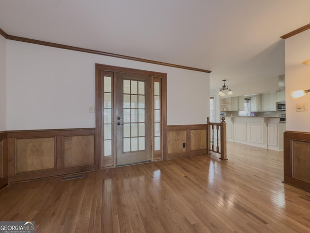 entryway with crown molding and light wood-type flooring