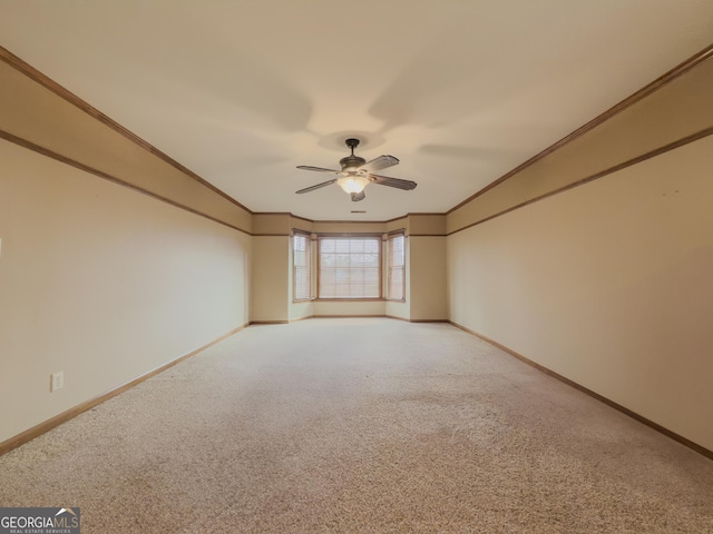 unfurnished room with crown molding, carpet flooring, and ceiling fan