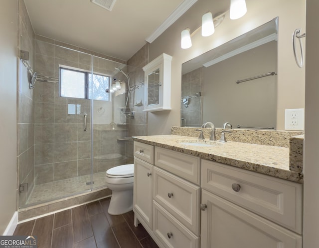 bathroom with vanity, an enclosed shower, crown molding, and toilet