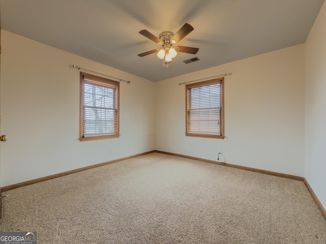 carpeted spare room featuring ceiling fan