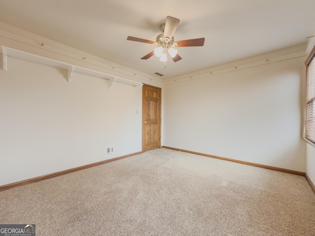 carpeted spare room with ceiling fan