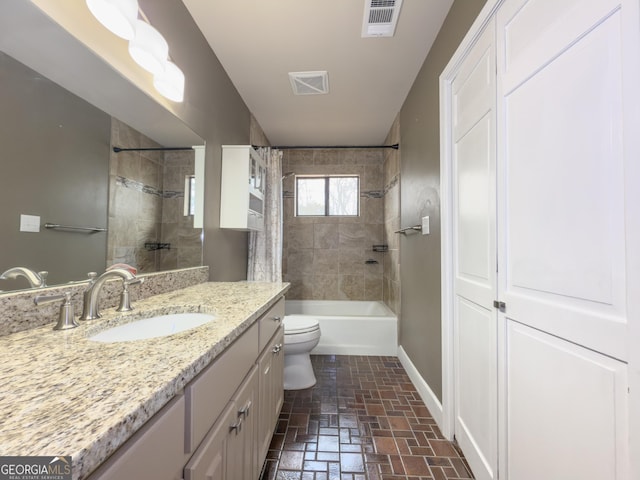 full bathroom with vanity, tiled shower / bath combo, and toilet