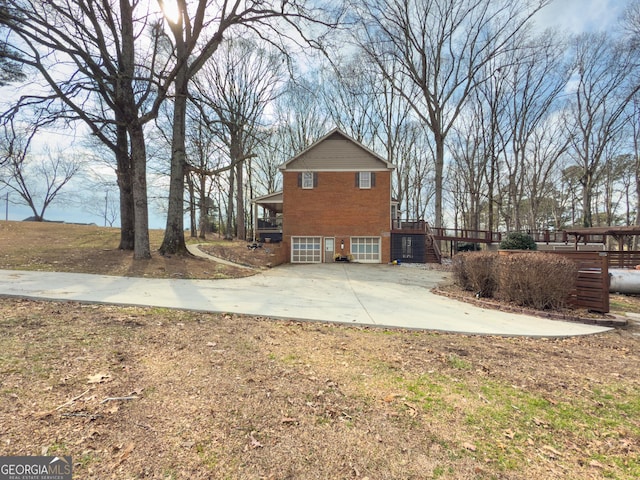 view of home's exterior with a garage and a wooden deck