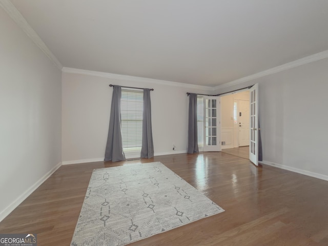 empty room featuring hardwood / wood-style floors, crown molding, and french doors