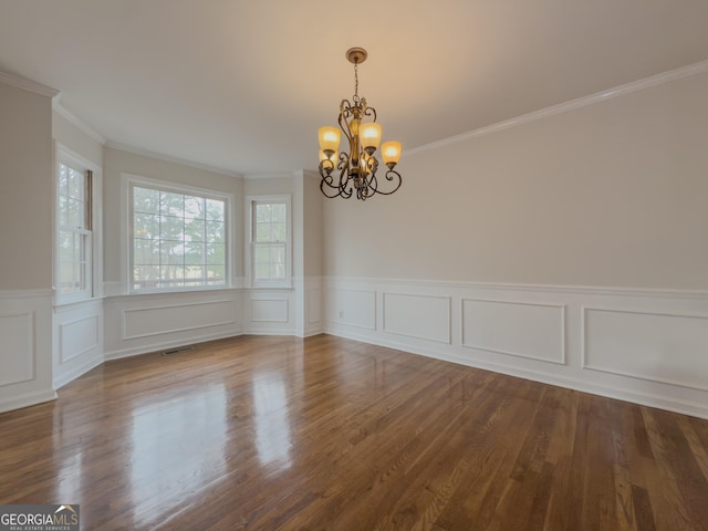 unfurnished room with ornamental molding, hardwood / wood-style floors, and an inviting chandelier