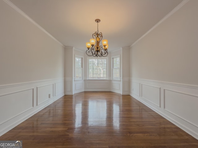 unfurnished dining area featuring crown molding, dark hardwood / wood-style flooring, and a chandelier