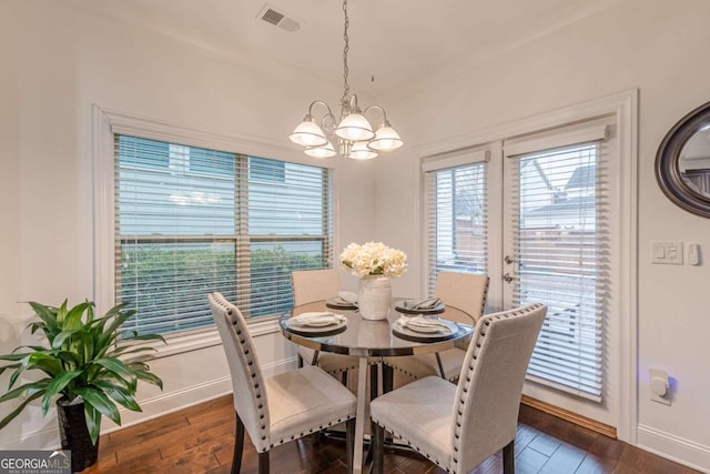 dining area with a notable chandelier and dark hardwood / wood-style flooring