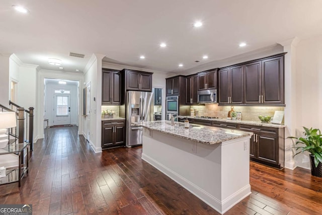 kitchen with sink, a center island with sink, appliances with stainless steel finishes, dark hardwood / wood-style floors, and decorative backsplash