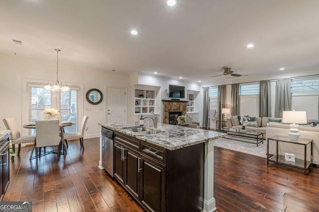 kitchen featuring pendant lighting, sink, light stone counters, an island with sink, and stainless steel dishwasher