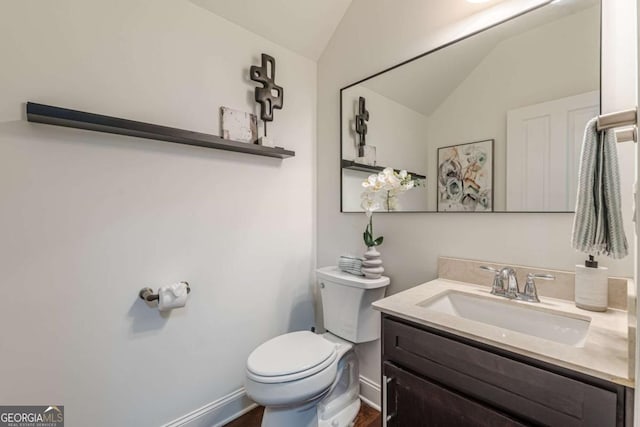 bathroom with lofted ceiling, vanity, and toilet