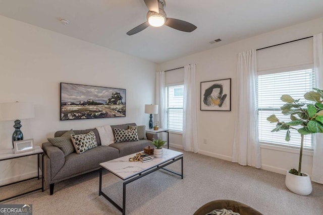 carpeted living room with ceiling fan