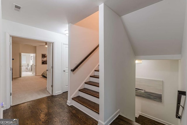 staircase featuring hardwood / wood-style flooring and vaulted ceiling