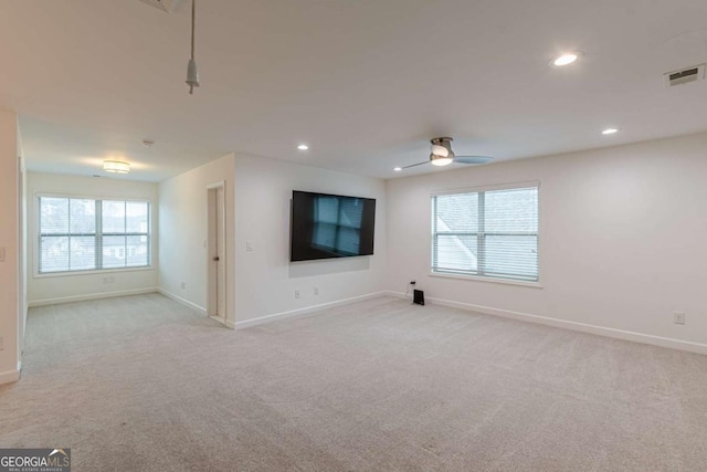 unfurnished living room featuring a wealth of natural light, light colored carpet, and ceiling fan