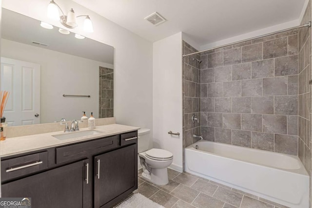 full bathroom featuring vanity, toilet, and tiled shower / bath