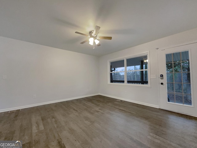 spare room with dark hardwood / wood-style floors and ceiling fan