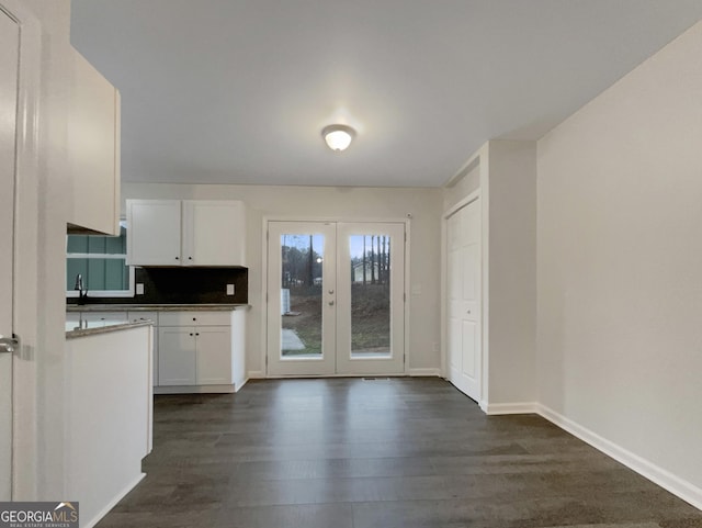 kitchen featuring dark wood-type flooring, tasteful backsplash, french doors, and white cabinets