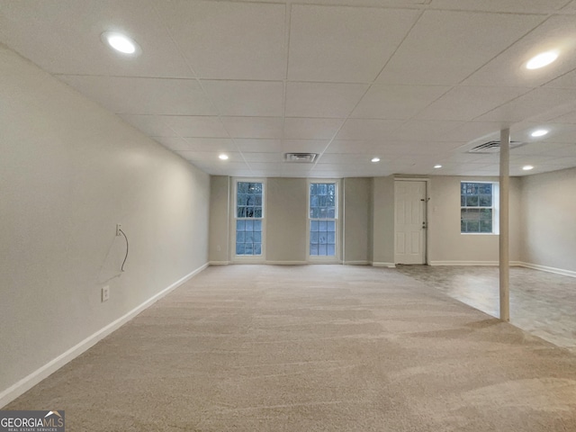 basement with light carpet and a paneled ceiling