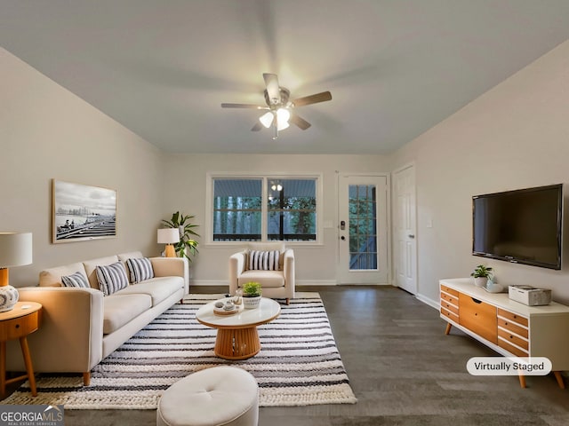 living room featuring dark wood-type flooring and ceiling fan