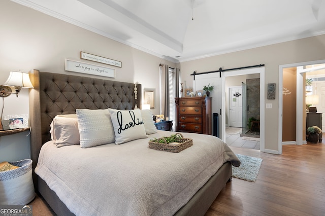 bedroom with lofted ceiling, wood-type flooring, ornamental molding, and a barn door