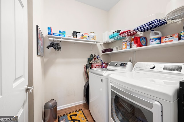 clothes washing area with separate washer and dryer and light hardwood / wood-style floors