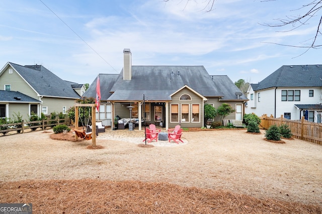 rear view of house with an outdoor fire pit and a patio