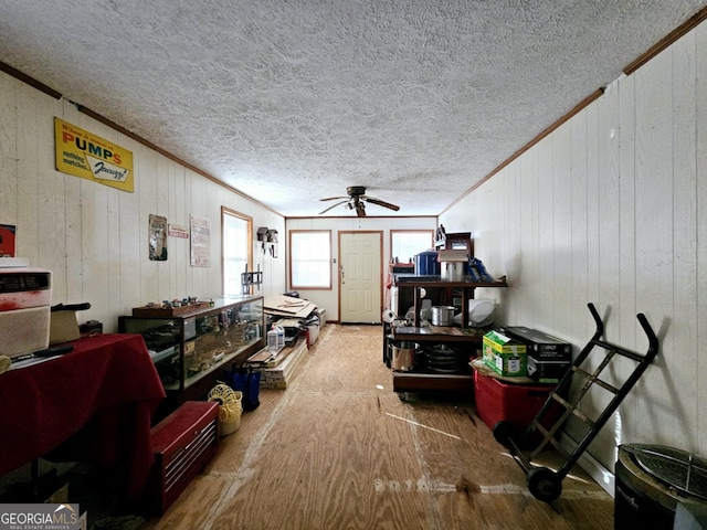 misc room with ornamental molding, wood-type flooring, ceiling fan, and a textured ceiling