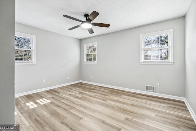 spare room featuring ceiling fan, light hardwood / wood-style floors, and a textured ceiling