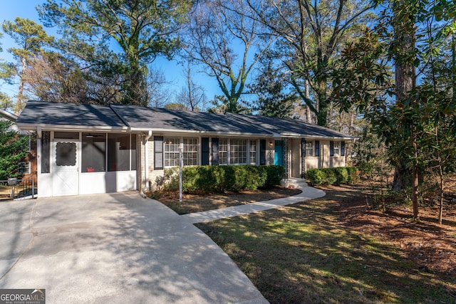 ranch-style home featuring a sunroom and a front yard