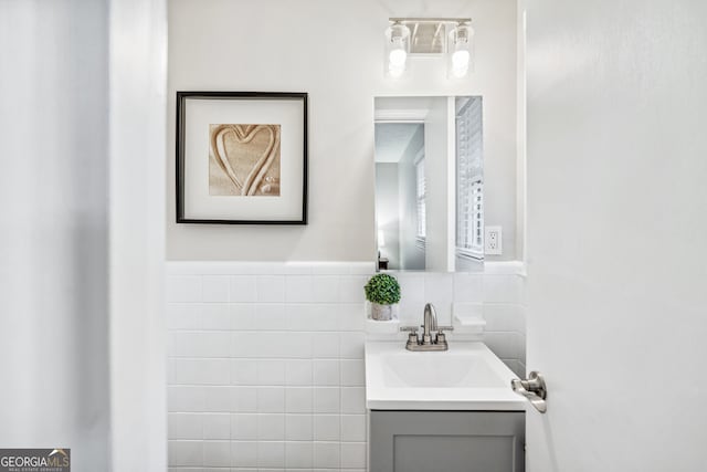 bathroom featuring vanity and tile walls