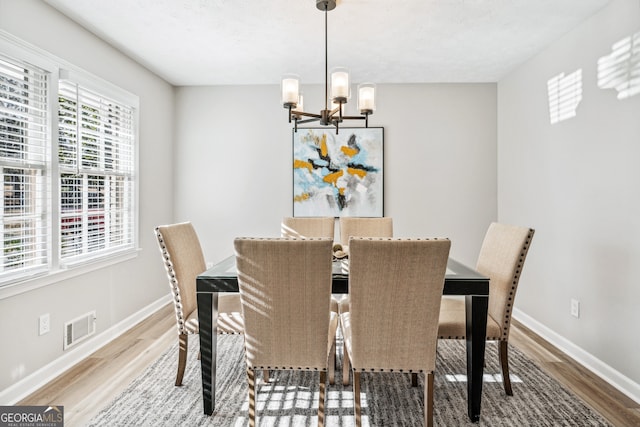 dining room with hardwood / wood-style flooring and a chandelier