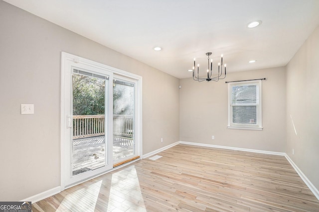 unfurnished dining area featuring a notable chandelier and light hardwood / wood-style flooring