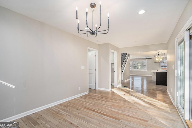 unfurnished dining area with light hardwood / wood-style flooring and a notable chandelier