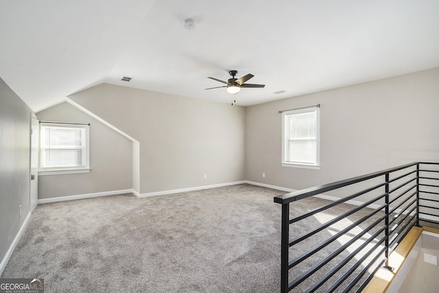 interior space featuring lofted ceiling, ceiling fan, and carpet