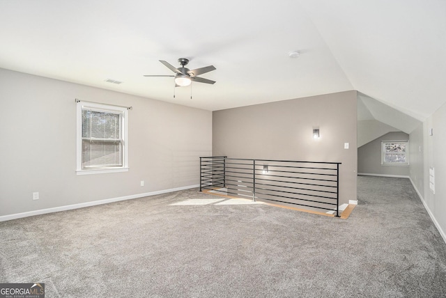 interior space with lofted ceiling, ceiling fan, and carpet flooring