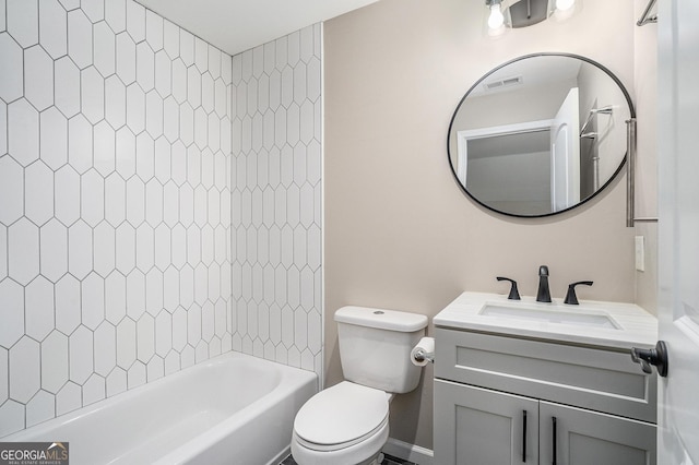 full bathroom featuring vanity, tiled shower / bath, and toilet