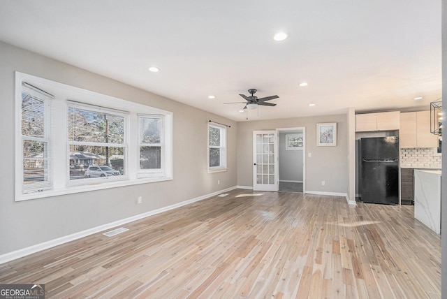 unfurnished living room with ceiling fan and light wood-type flooring