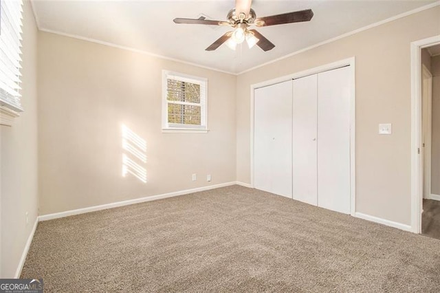 unfurnished bedroom featuring crown molding, carpet floors, a closet, and ceiling fan